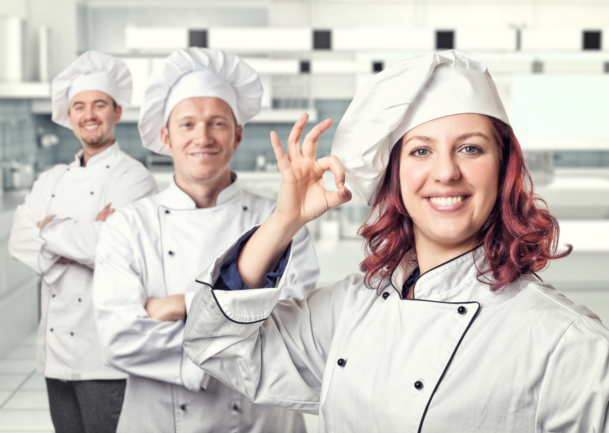 Instructor smiling with students in kitchen